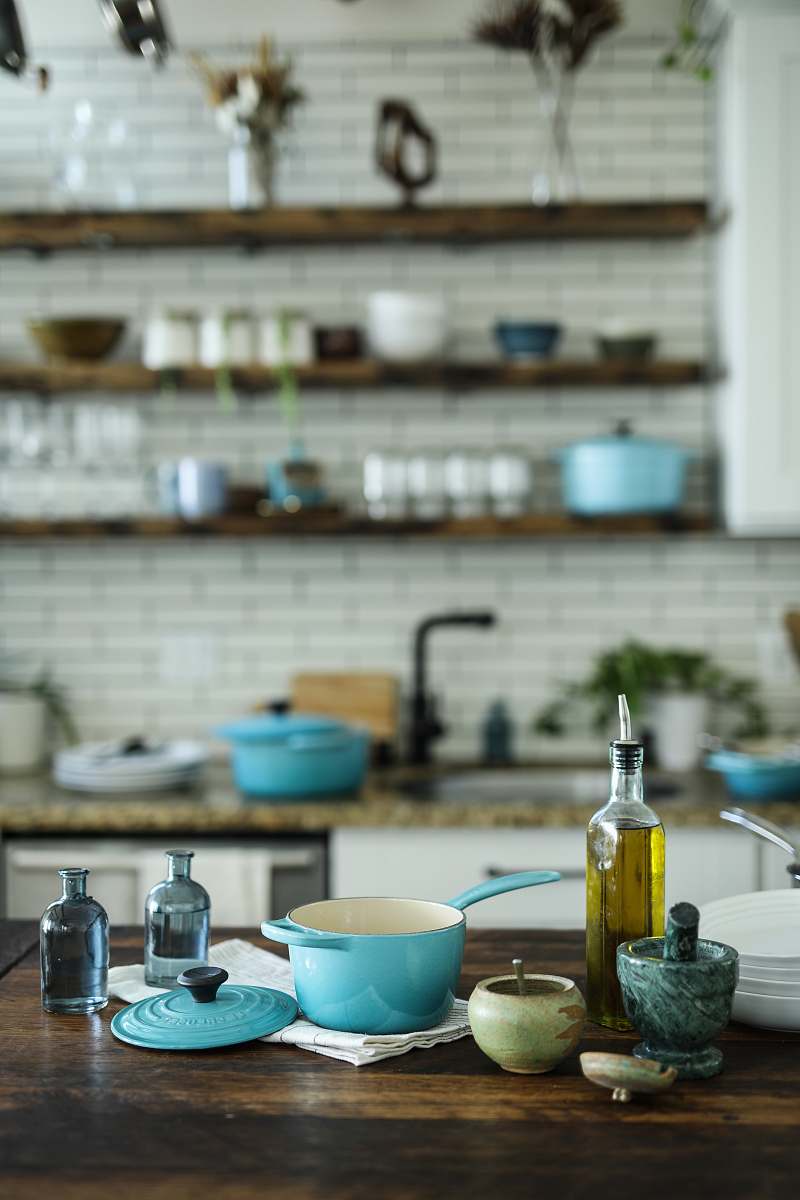 home decor blue and white casserole near olive oil bottle on table bowl